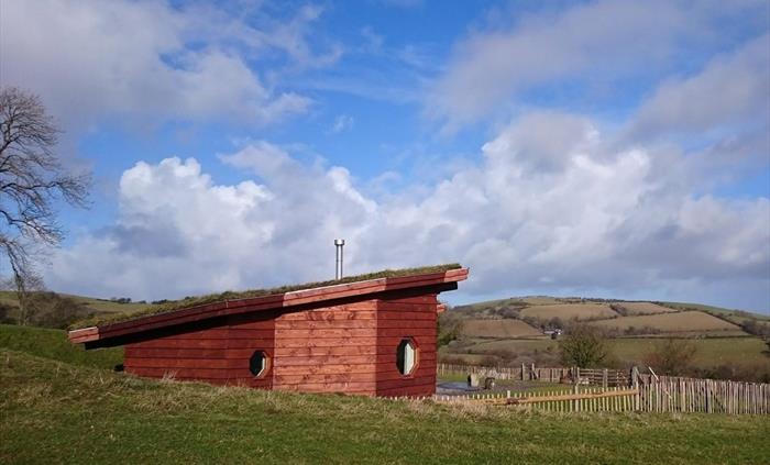 Set within wild meadows, Aerona eco lodge blends turf and timber for a truly peaceful retreat. Its soft curves and glowing windows invite guests to un